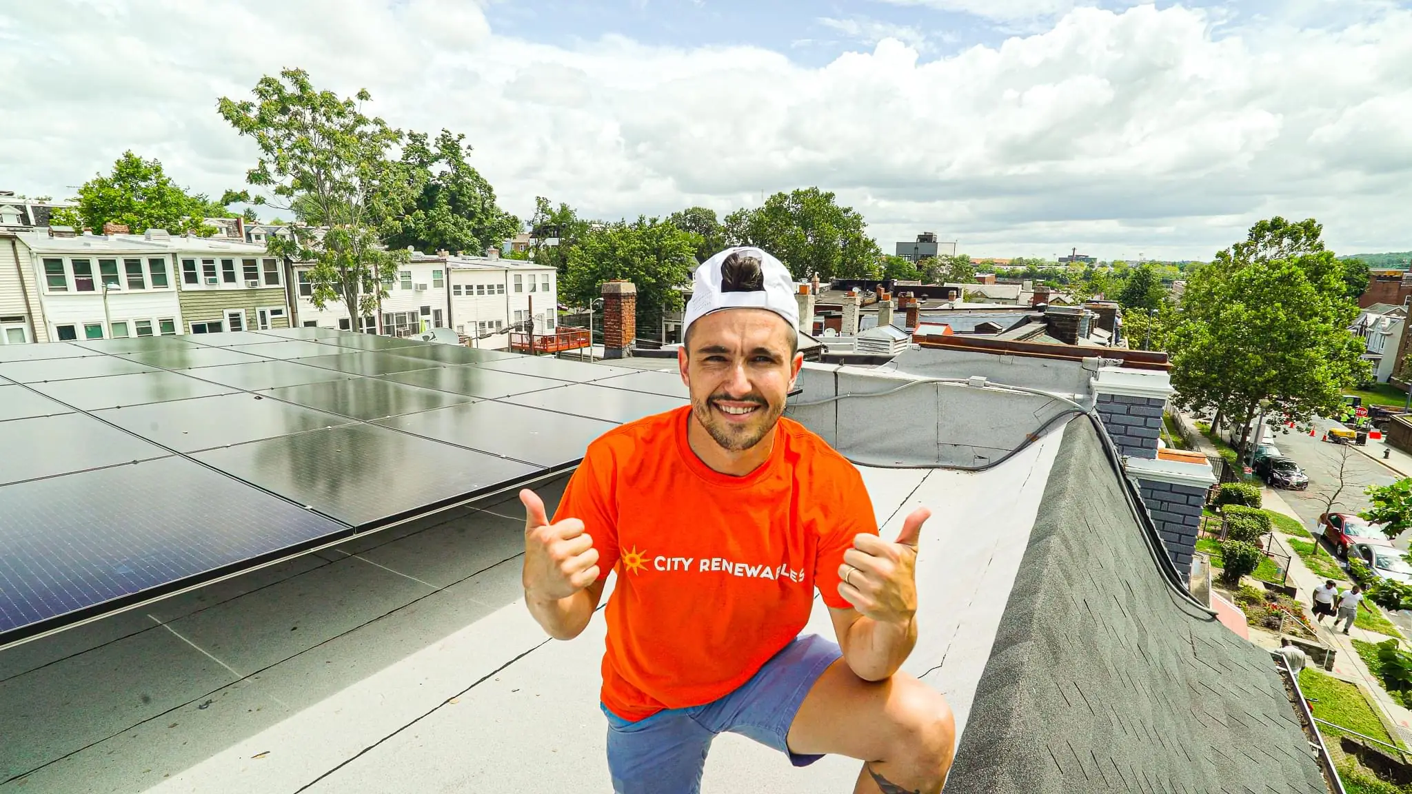 Ben beside a rooftop solar installation