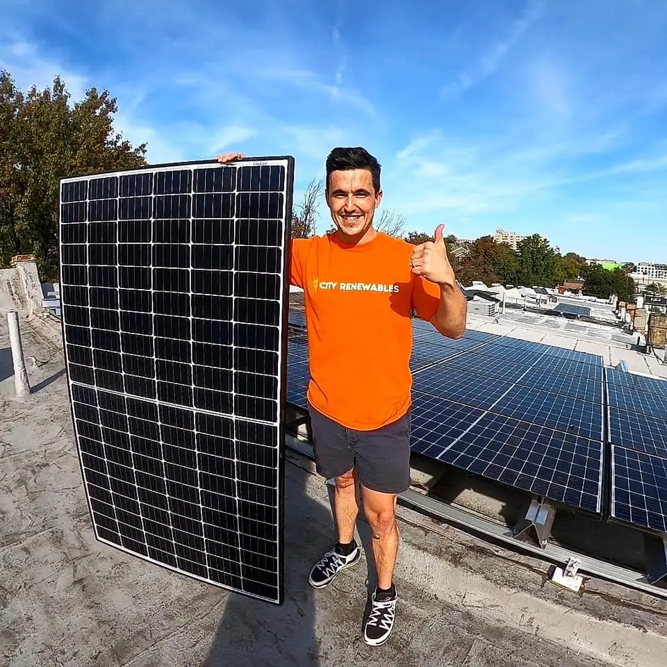 Ben with a solar panel on a DC roof